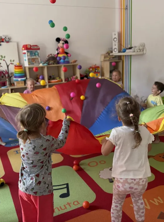 Zabawa z chustą animacyjną w sali przedszkolnej
