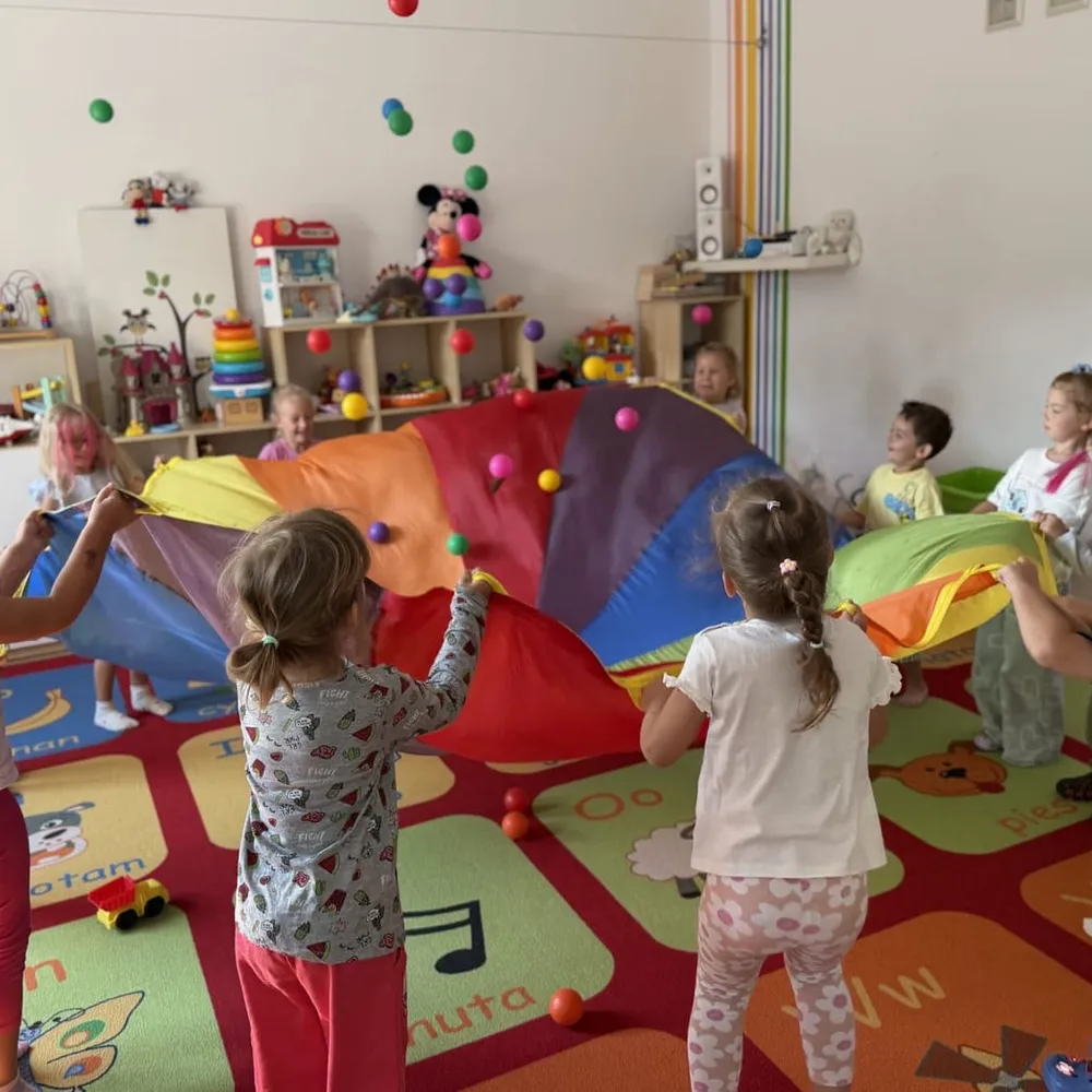 Zabawa z chustą animacyjną w sali przedszkolnej